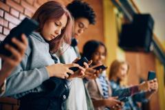 Un groupe d'adolescents, tous concentrés sur leurs smartphones